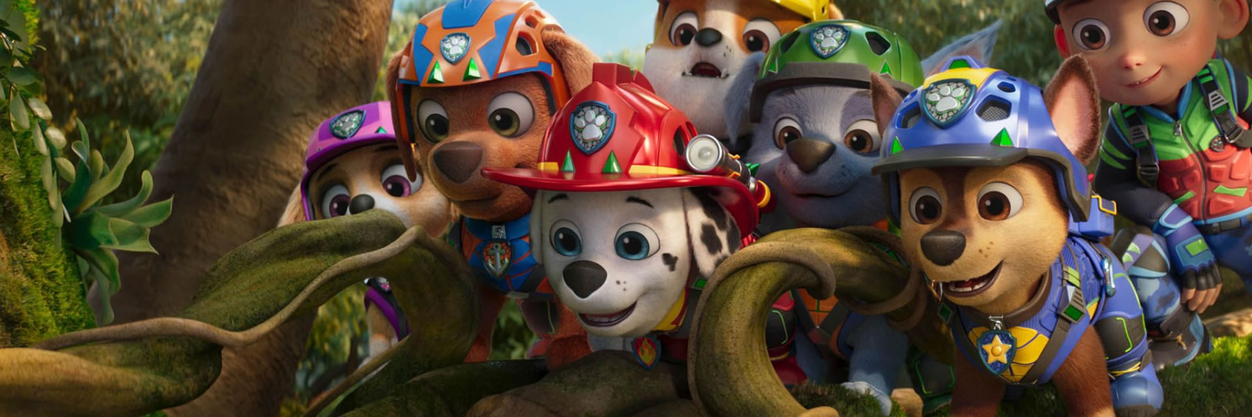 Group of PAW Patrol puppies wearing helmets in a forest, looking toward the camera with curious expressions, ready for action.