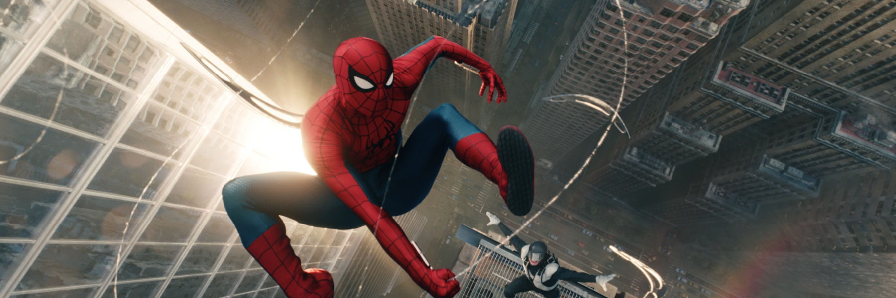 Spider-Man in a red-and-blue suit swinging on a web between tall skyscrapers above a city skyline.